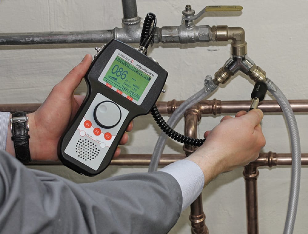 Plumber testing pipes with electronic leak detection equipment in Seaside