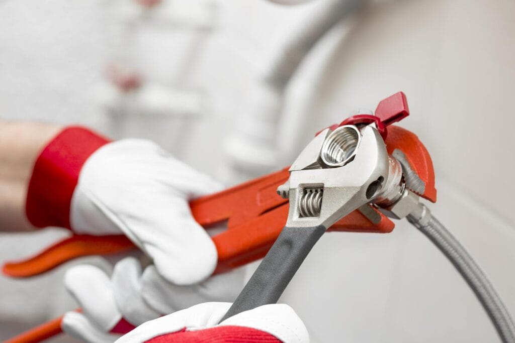 Plumber holding pipe wrenches for an emergency repair in Seaside