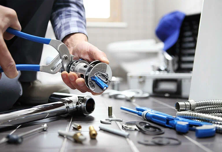 Technician repairing a plumbing fixture with professional tools in Seaside