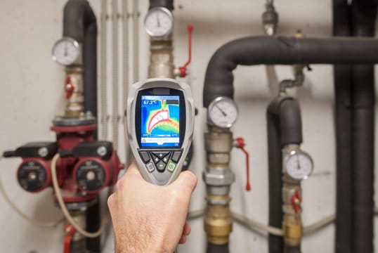 Plumber using a thermal imaging camera to inspect pipes in Seaside