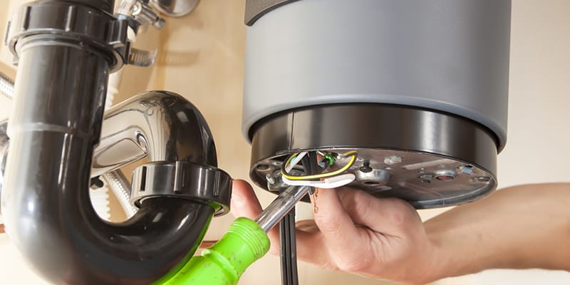 Technician repairing the heating element of a water heater in Seaside