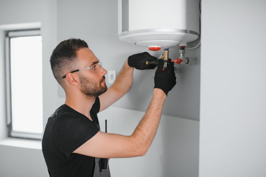 Technician performing water heater maintenance in Seaside