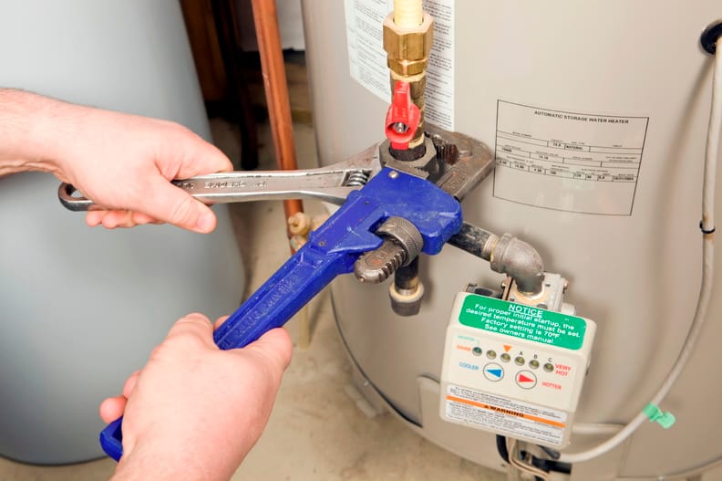 Plumber repairing a water heater valve in Seaside